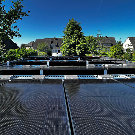 Flach aufgest&auml;nderte Photovoltaikmodule auf dem Flachdach einer Garage. Man sieht die Ballastierung der Anlage.